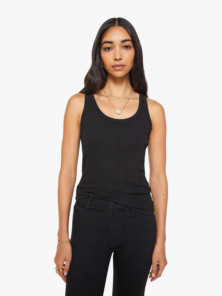 Front view of a woman in black  tank with wide straps and a slightly shrunken fit. 
