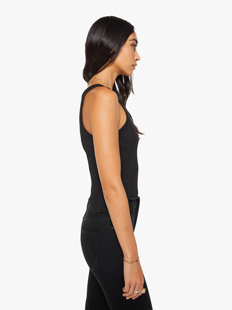 Side view of a woman in black  tank with wide straps and a slightly shrunken fit. 