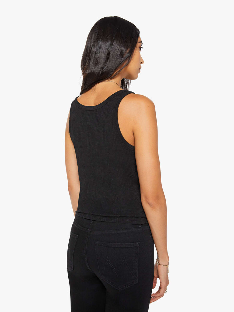 Back view of a woman in black  tank with wide straps and a slightly shrunken fit. 