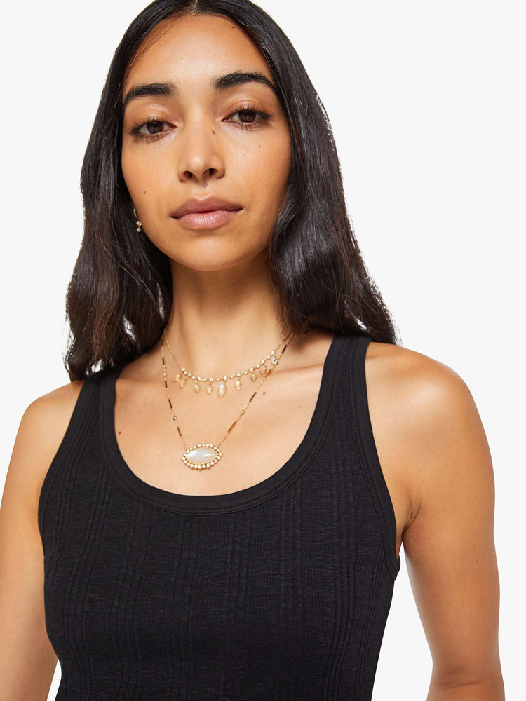 Close up view of a woman in black  tank with wide straps and a slightly shrunken fit. 