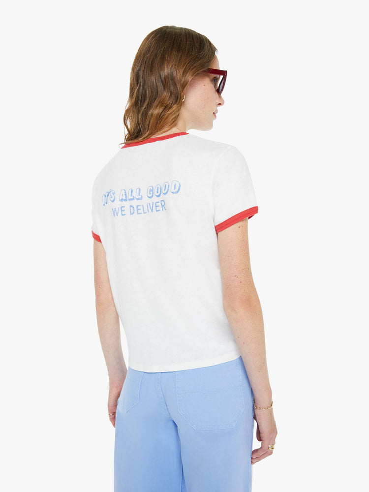Back view of a woman in white crewneck tee with a faded light blue pizza graphic with text on the front.