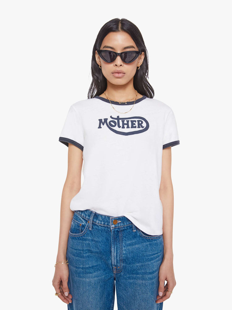 Front view of a woman in a white tee with navy trim, the tee features MOTHER's name on the front.