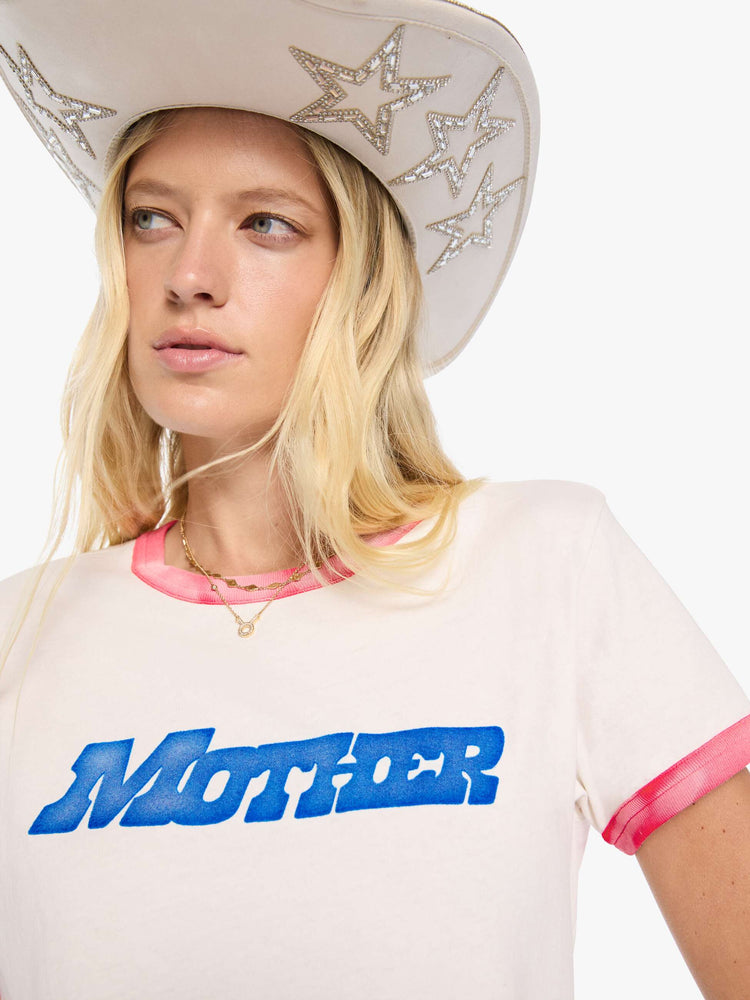 Close up view of a woman in a white tee with sun-faded red trim extra-short sleeves and a slightly shrunken fit with a flocked MOTHER graphic across the chest.