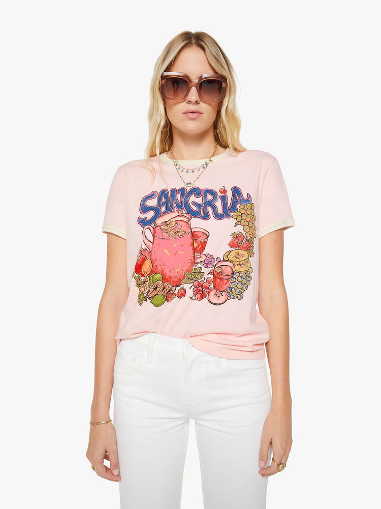 Front view of a woman in a light pink with cream trim tee with extra-short sleeves and a slightly shrunken fit.