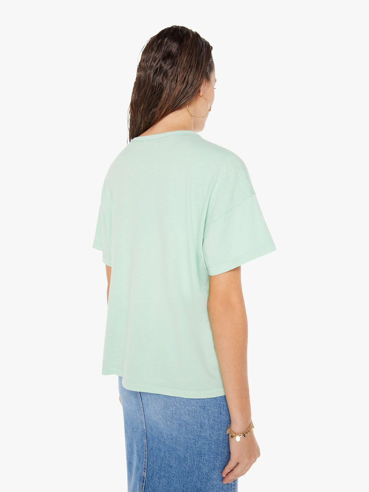 Back view of a woman wearing a light teal crew neck tee with an oversized fit.