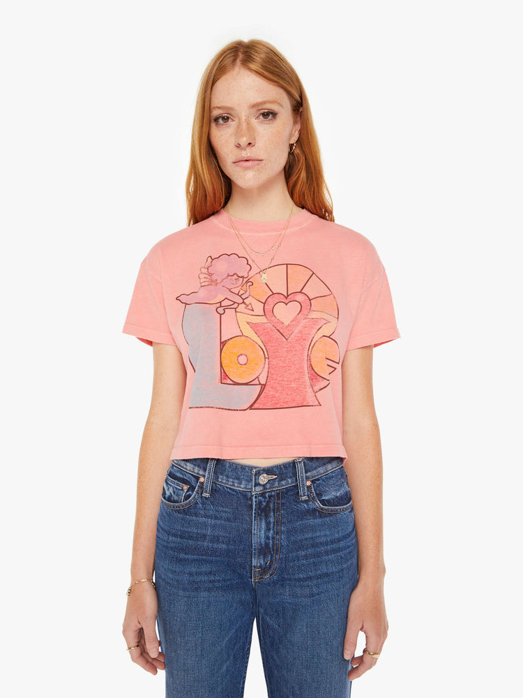 Front view of a womens pink crew neck tee featuring a cropped body and a LOVE with Cupid graphic.