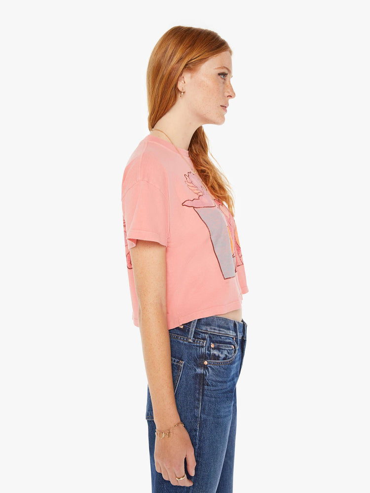 Side view of a womens pink crew neck tee featuring a cropped body and a LOVE with Cupid graphic.