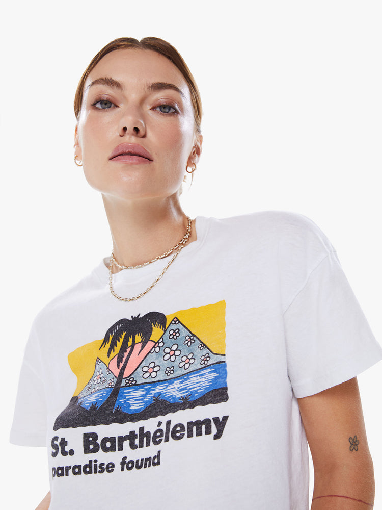 Close up view of a woman crewneck tee with drop shoulders, a cropped hem and a boxy fit in a white hue with colorful tourist graphic.