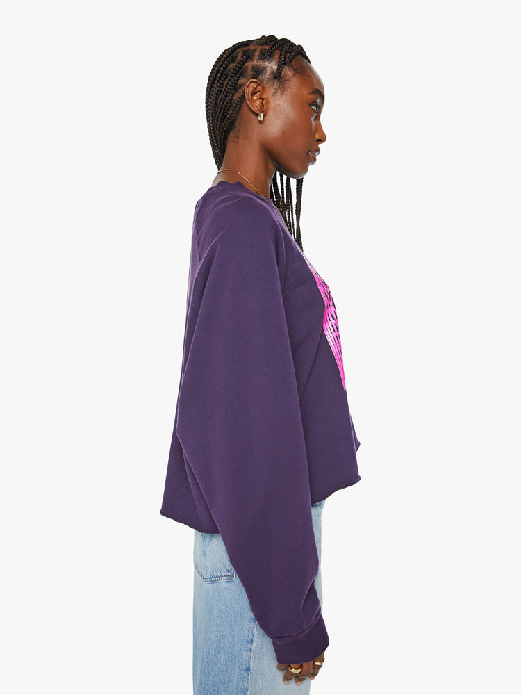 Side view of a woman's cropped sweatshirt with a crew neck, drop shoulders and a raw hem in dark purple.