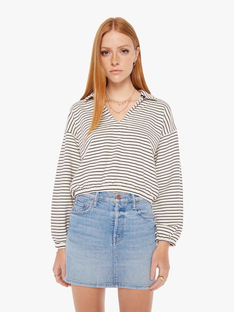 Front view of a womens black and white striped pullover featuring an opened collar and a cropped, cinched waist.
