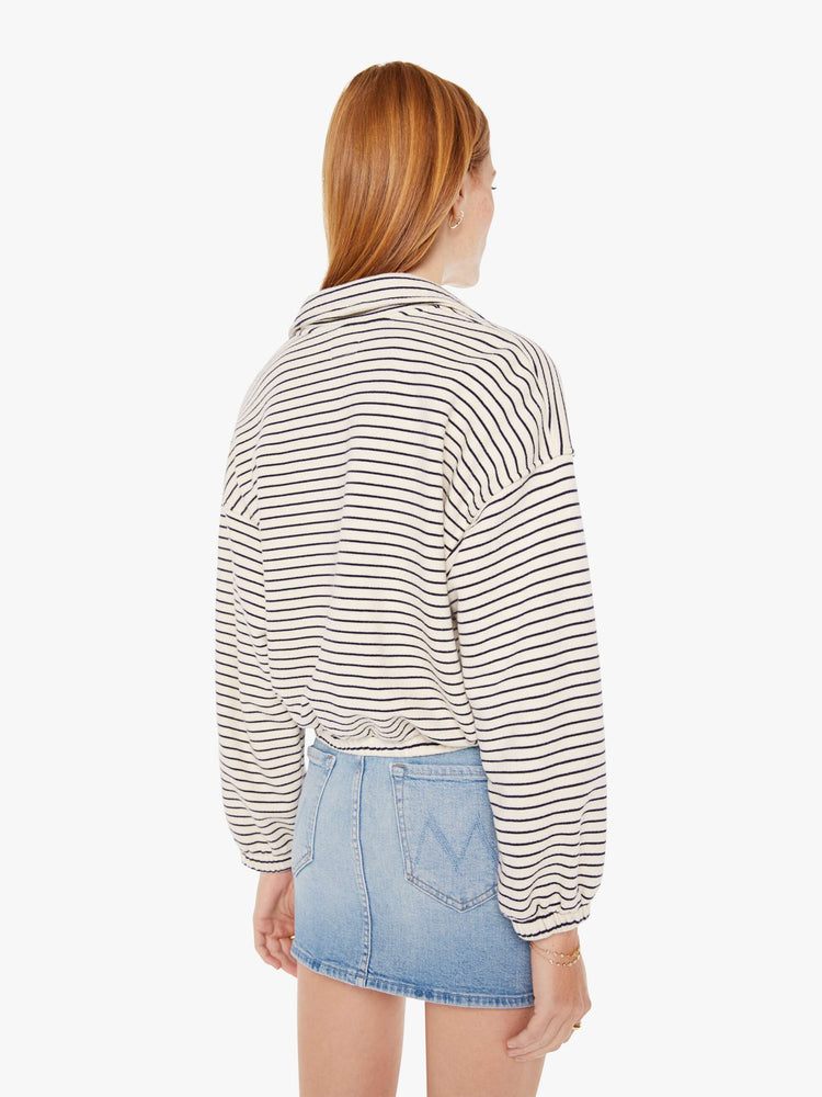 Back view of a womens black and white striped pullover featuring an opened collar and a cropped, cinched waist.
