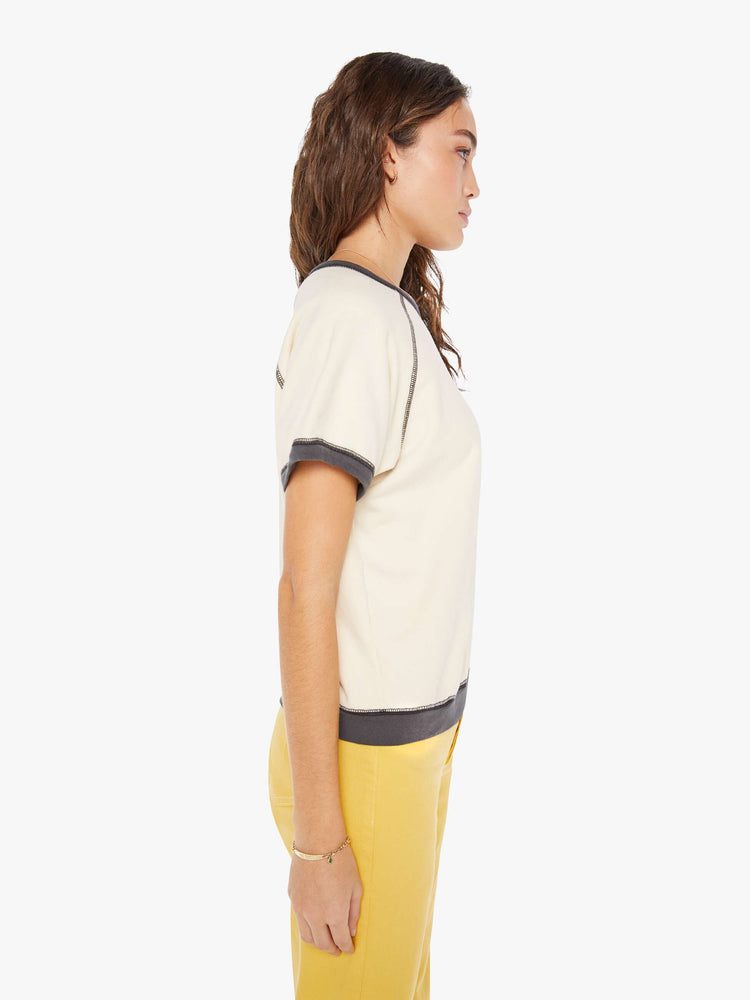 Side view of a woman in a vintage-inspired top designed with short sleeves, a wide crewneck and a slightly oversized fit.