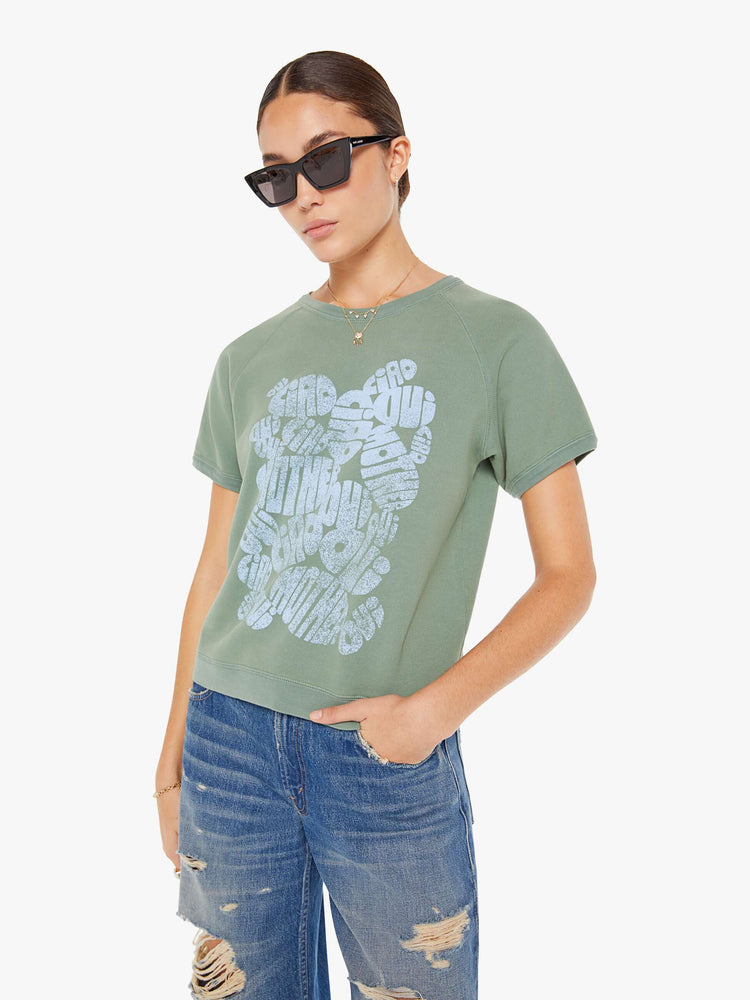 Front view of a womens faded green crew neck short sleeve sweatshirt featuring a light blue graphic.