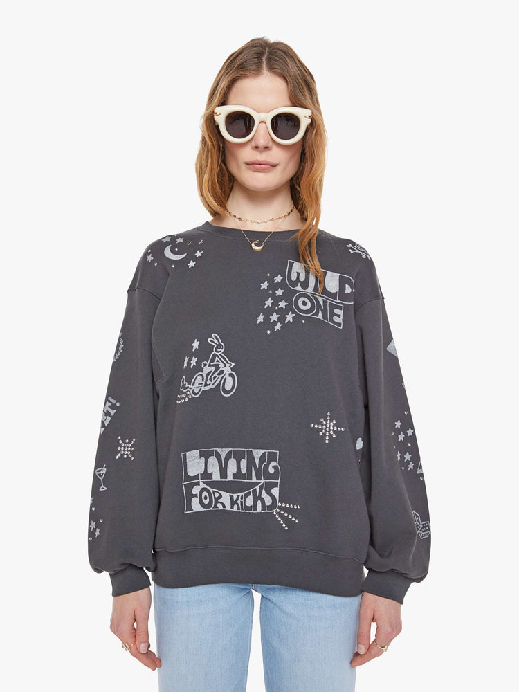 Front view of a woman in a faded black oversized sweatshirt with a crewneck, drop shoulders, inset balloon sleeves and a relaxed fit