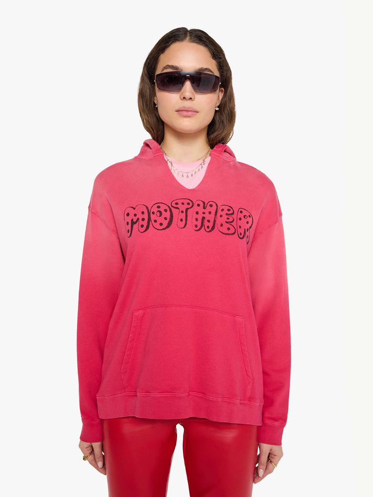 Front view of a woman in a hoodie is designed in hot pink with sun fading across the shoulders and MOTHER's name in faded black text on the front.