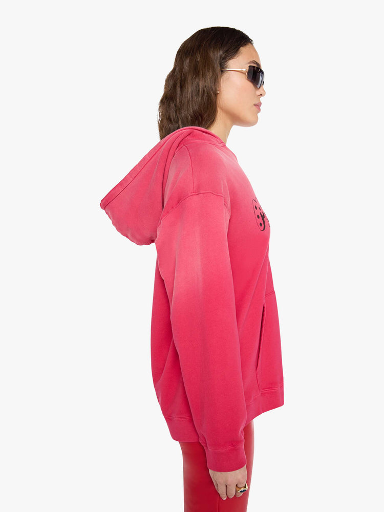 Side view of a woman in a hoodie is designed in hot pink with sun fading across the shoulders and MOTHER's name in faded black text on the front.