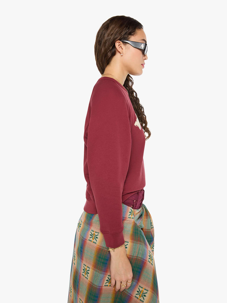 Side view of a woman in a maroon with MOTHER's name in cream and a pastel eagle graphic in fuzzy puff print sweater.