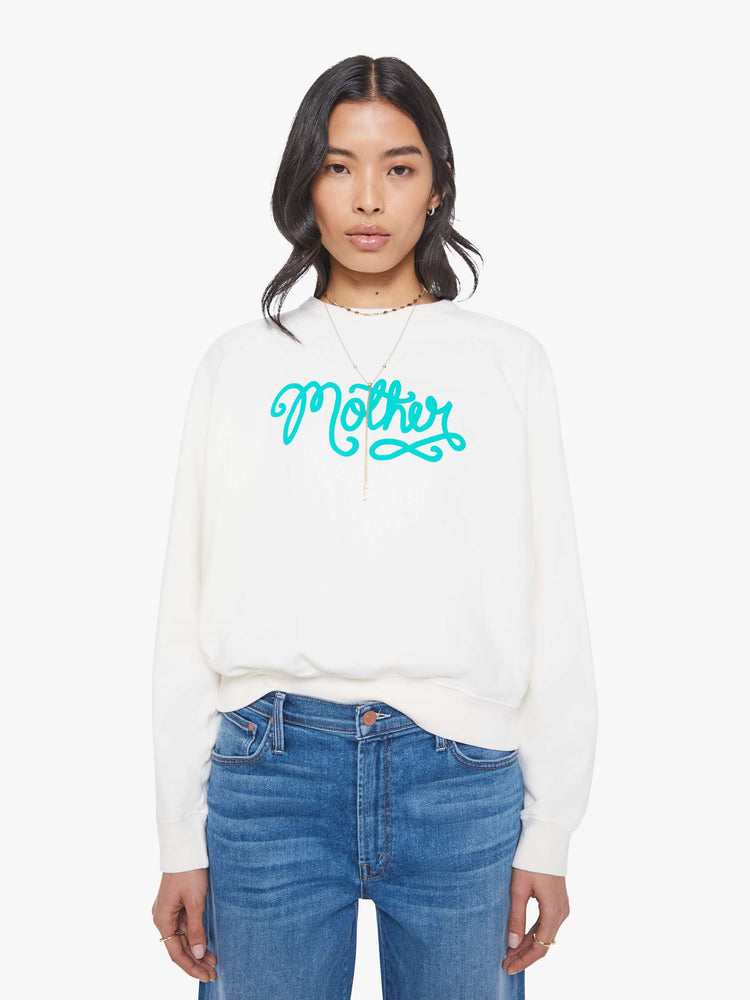 Front view of a woman in a white with sweatshirt with a crewneck, ribbed hems and a slightly oversized fit.