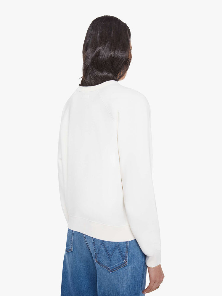 Back view of a woman in a white with sweatshirt with a crewneck, ribbed hems and a slightly oversized fit.