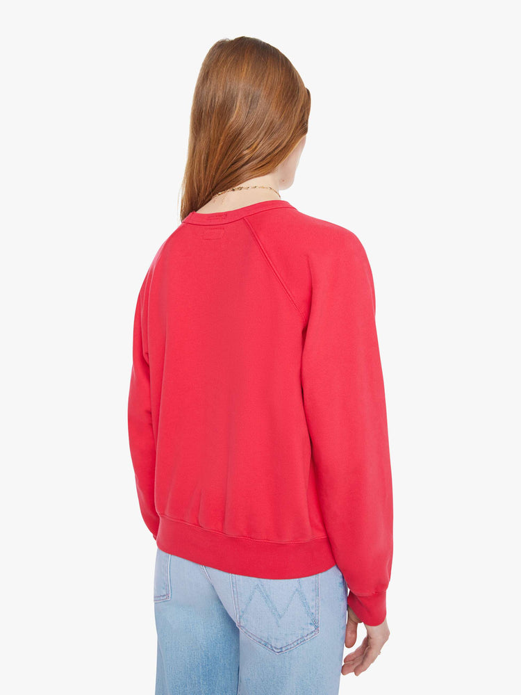 Back view in a woman in a crewneck sweatshirt in red with a white text graphic and MOTHER's name on the front.