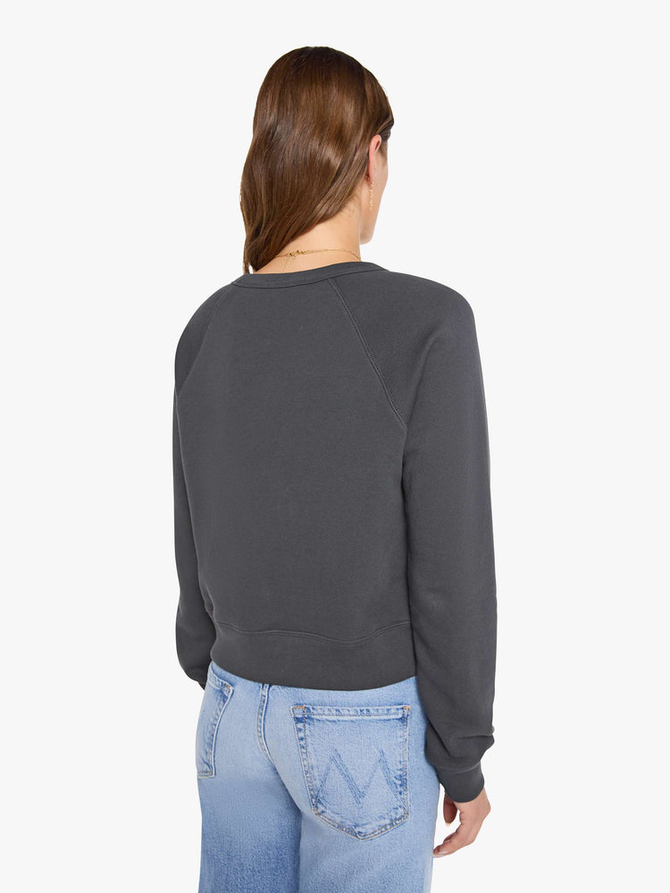 Back view of a woman in a faded grey sweatshirt features a fuzzy hot pink record graphic and text in highlighter yellow and blue on the front.
