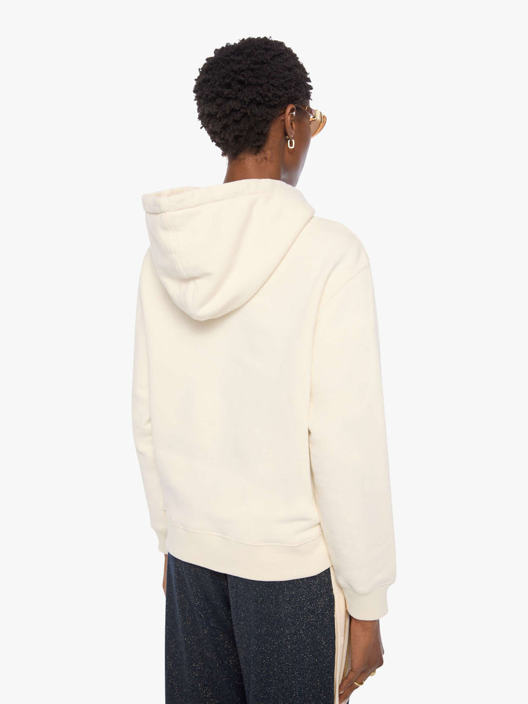 Back view of a woman in an off-white hoodie with an eyelet-embroidered lace detail on the front.