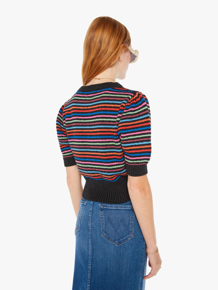 Back view of a woman knit top with a crew neck, elbow-length balloon sleeves and a thick ribbed hem in black with neon stripes.