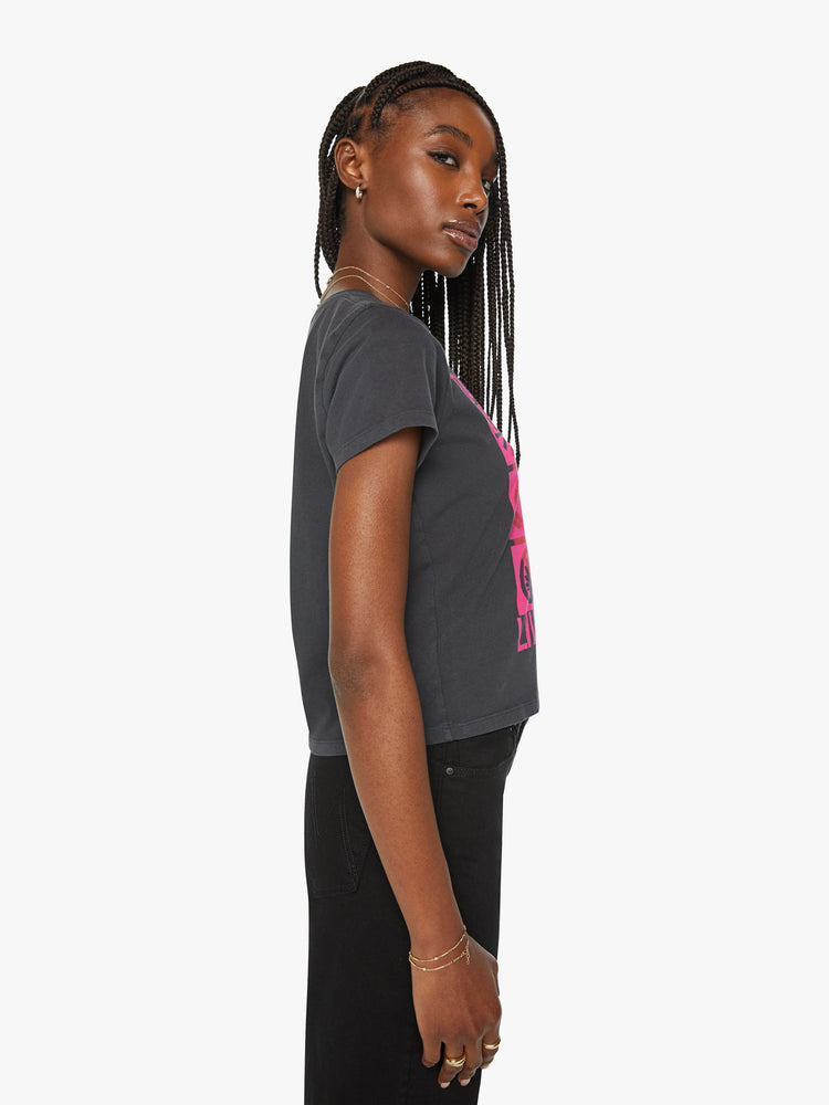 Side view of a woman classic crewneck with short sleeves, a cropped hem and a slim fit in a faded black with bright pink and red graphic.