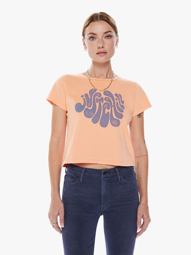 Front view of a women crewneck with short sleeves, a cropped hem and a slim fit in an orange hue with a lavender graphic.
