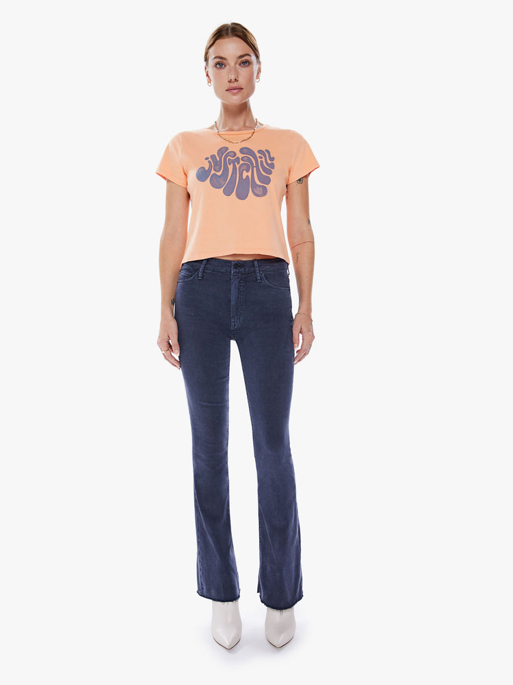 Full body view of a women crewneck with short sleeves, a cropped hem and a slim fit in an orange hue with a lavender graphic.