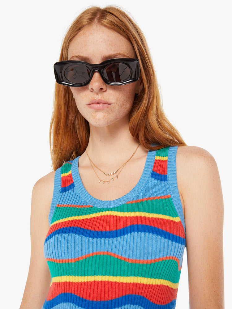 Close up view of a woman striped midi dress in a rainbow of primary colors features a slim fit, scoop neck, thick straps and a calf-length hem.
