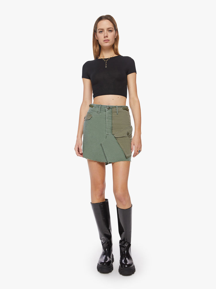 Front view of a woman argo mini skirt with a high rise, patch pockets and a slightly pointed hem in an army-green hue with pockets made from deadstock fabric.