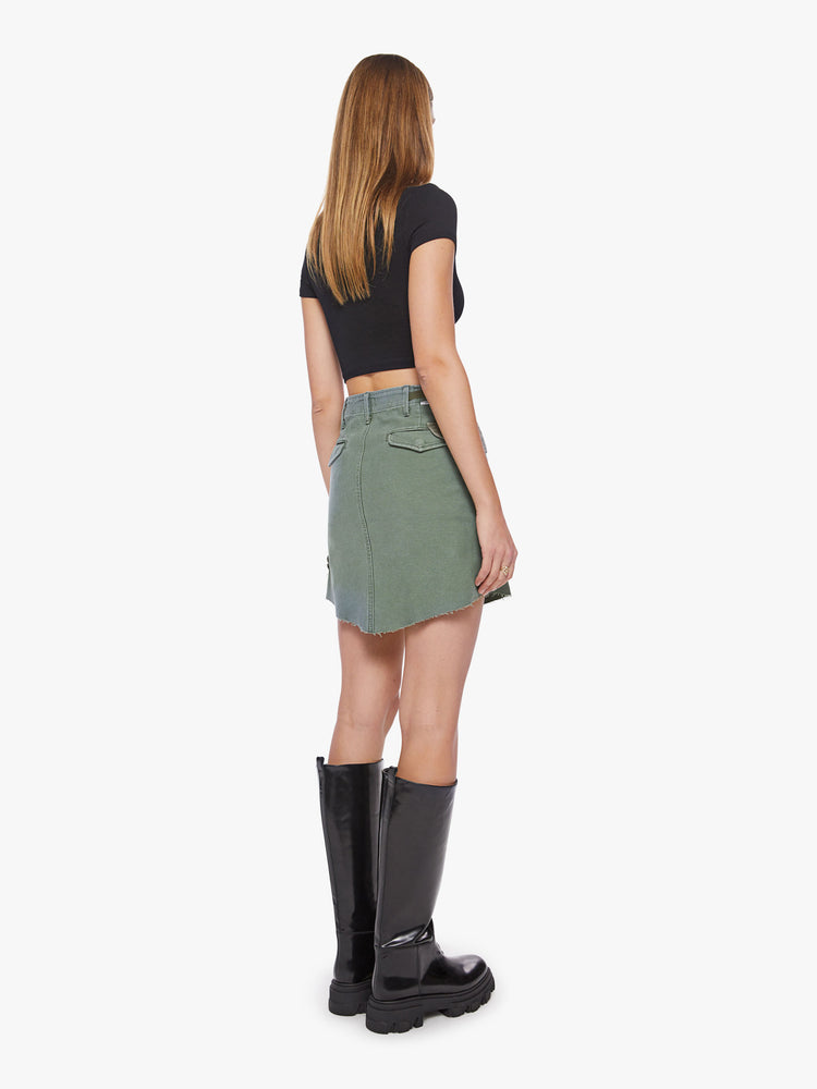 Back view of a woman argo mini skirt with a high rise, patch pockets and a slightly pointed hem in an army-green hue with pockets made from deadstock fabric.