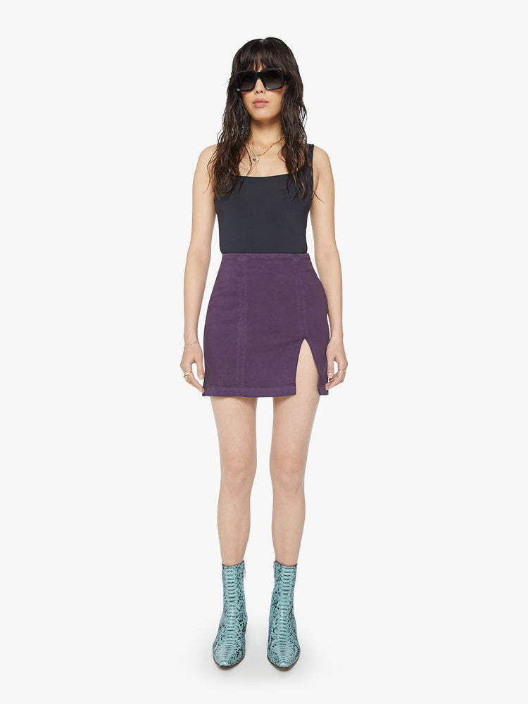 Front view of a woman high-waisted mini skirt with a thigh slit, narrow fit and a side zip closure in a blackberry-purple.
