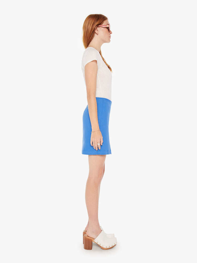 Side view of a woman in high-waisted mini skirt with a thigh slit, narrow fit and a side zip closure in a bright blue.