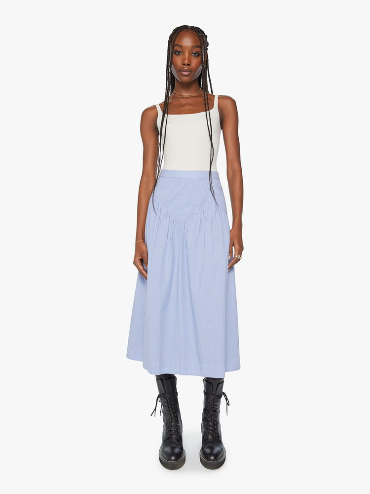Front view of a high waisted midi skirt with a ruffled yoke, calf-length hem and a flowy fit  in a blue and white stripe pattern with a quilted snowflake motif at the hips. 