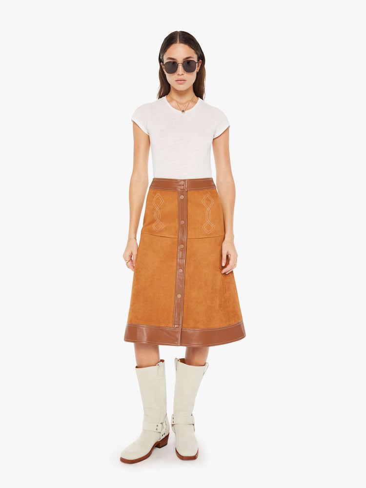 Front view of a brown faux leather skirt featuring a high rise and contrast trim.