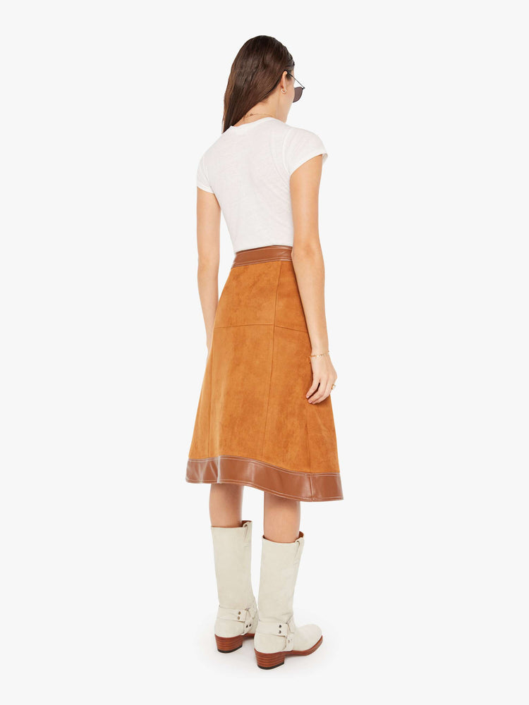 Back view of a brown faux leather skirt featuring a high rise and contrast trim.