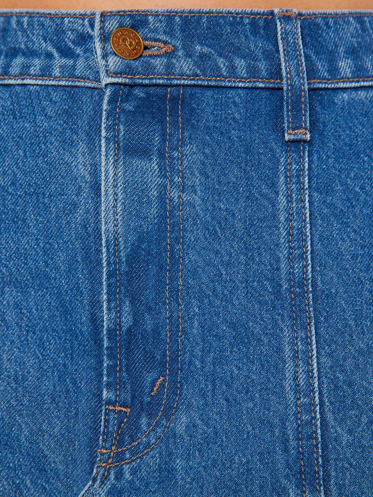 Swatch view of a woman mid blue wash high-rise skirt is designed with thigh-high slits up the front, a frayed hem and a flowy fit.