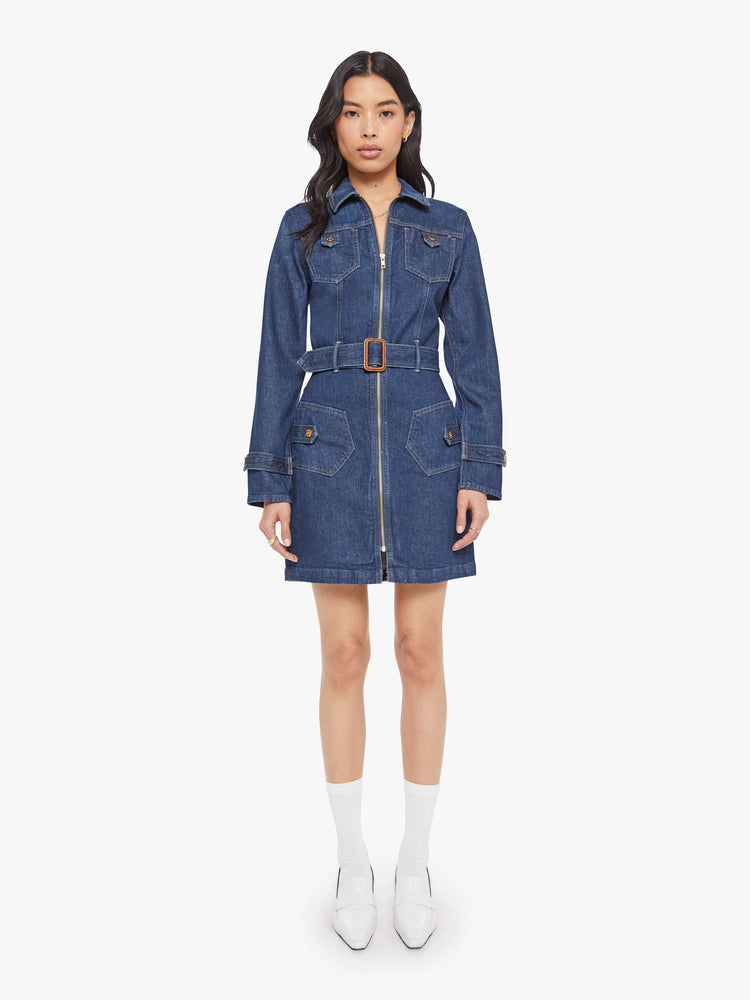 Front view of a woman in collared denim mini dress with long sleeves, a zip closure, belted waist, patch pockets and a hem that hits mid-thigh.