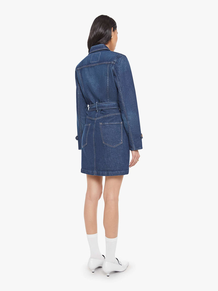 Back view of a woman in collared denim mini dress with long sleeves, a zip closure, belted waist, patch pockets and a hem that hits mid-thigh.