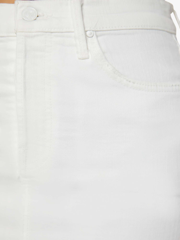 Detailed view of a white midi skirt with a button fly, slim fit and thigh-high front slit.