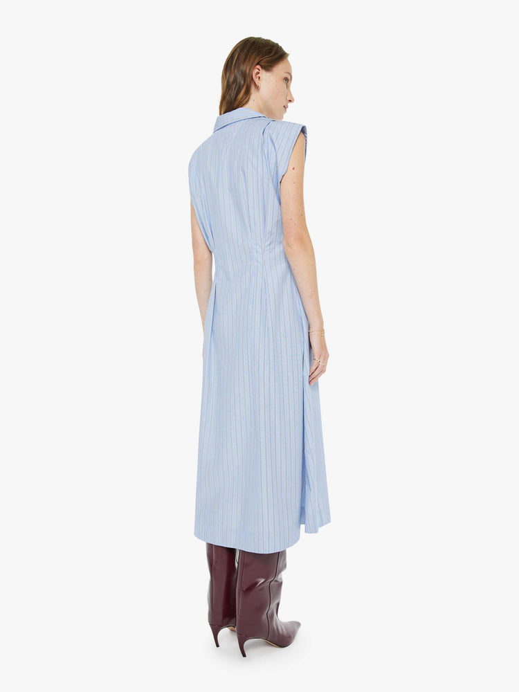 Back view of a woman in a sleeveless button-up dress with a collared neck, fitted waist and a flowy A-line skirt that hits at the calf.