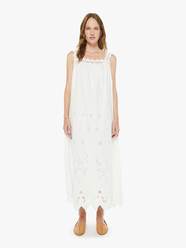 Front view of a woman in a white embroidery vintage-inspired maxi dress with a square neck, thick embroidered straps and a loose, flowy fit. 