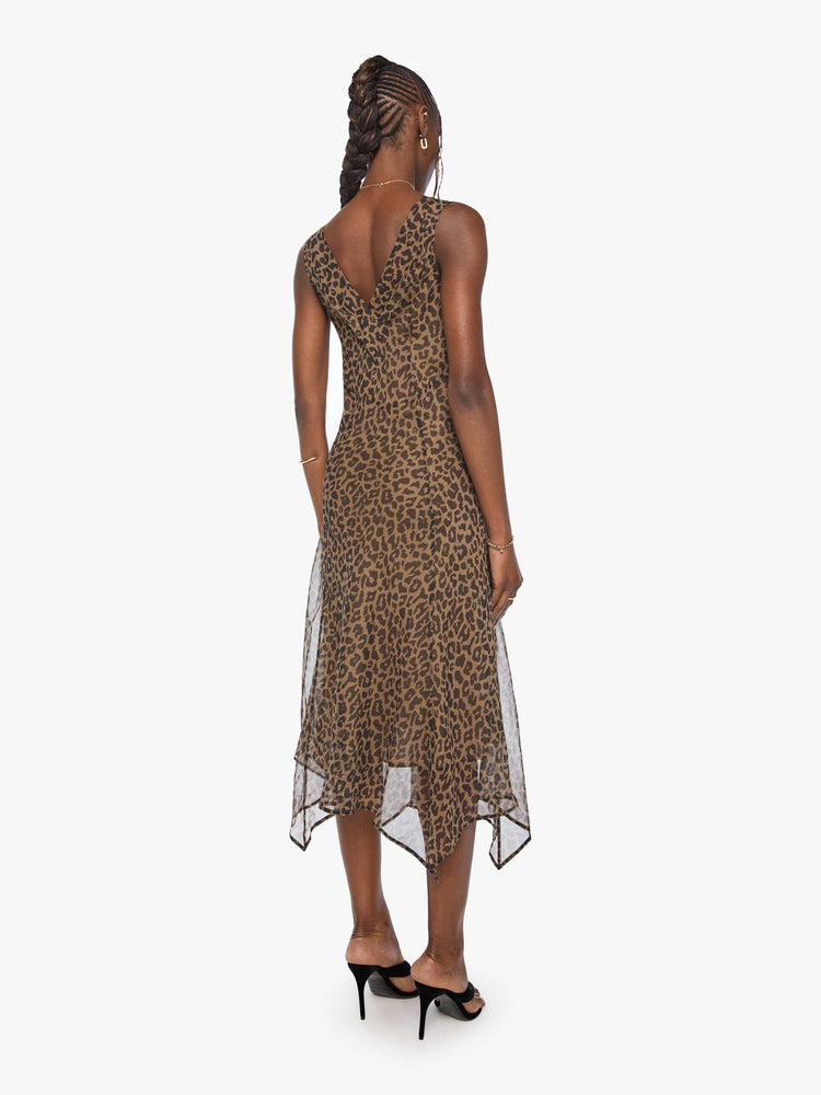 Back view of a woman in cheetah  V-neck dress with thick straps, an A-line fit and a flowy, uneven hemline that hits at the calf. 