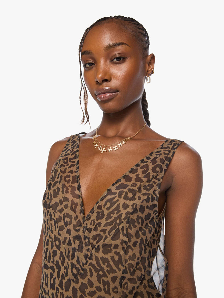 Close up view of a woman in cheetah  V-neck dress with thick straps, an A-line fit and a flowy, uneven hemline that hits at the calf. 