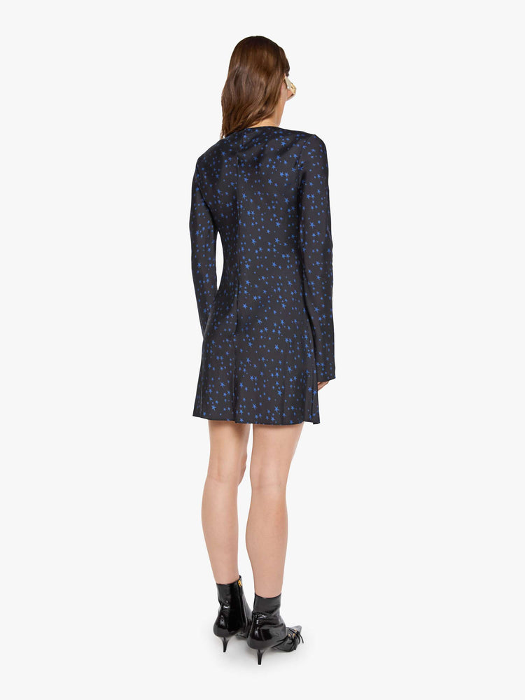 Back view of a woman wearing  a bias-cut mini dress with a wide crewneck, long sleeves, a thigh-length hem and a pull-on, zipless design. 