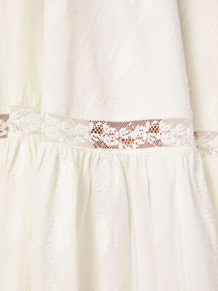 Swatch view of a woman in a white flowy maxi skirt with a high rise, elastic waist and a calf-length hem.