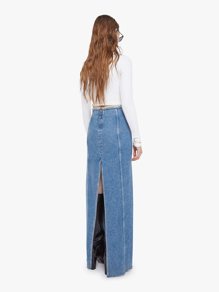 Back view of a med blue high-waisted skirt is designed with a frayed waistband and hem, back-zip closure, pintuck details down the front and a loose fit.
