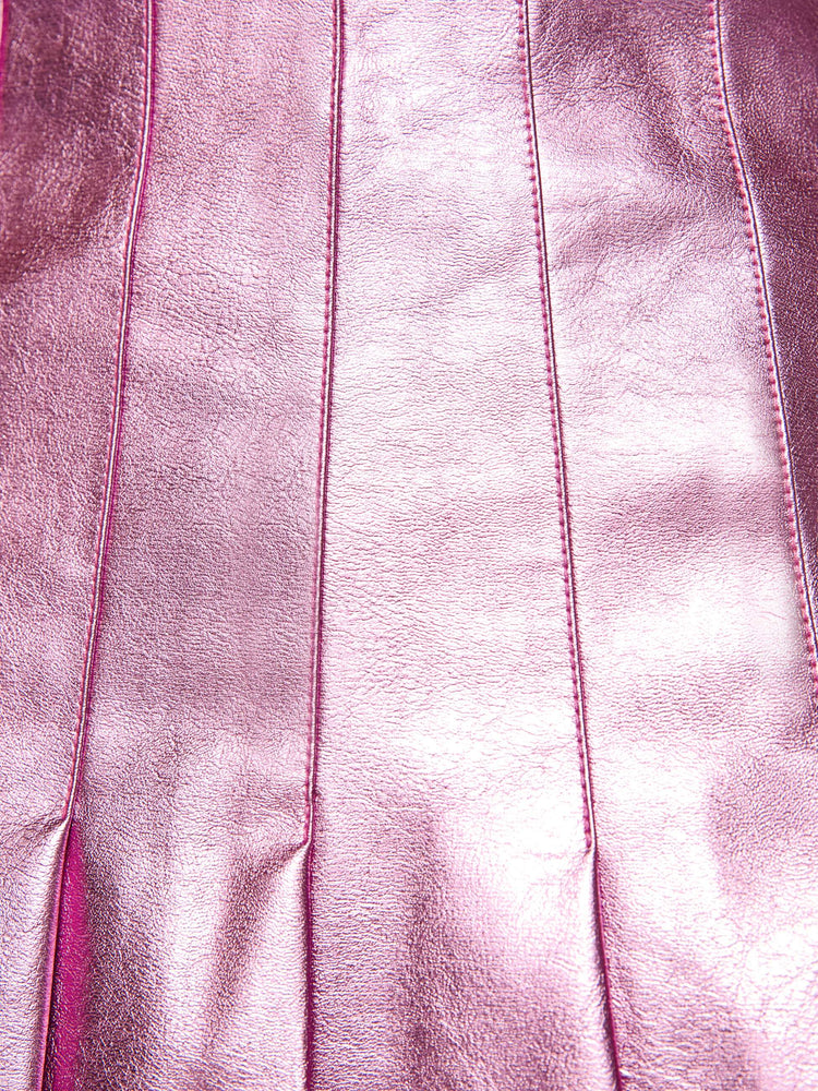 Swatch view of a woman in a reflective light pink faux leather pleated mini skirt with a high rise, wide pleats and a thigh-grazing hem. 